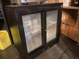 an image of a glass door refrigerator in a kitchen
