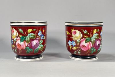 une paire de vases rouges ornés de motifs floraux, posés sur une table