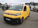une camionnette Citroën garée sur un parking devant un immeuble