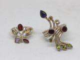 a pair of earrings with multi colored stones on a white surface