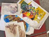 a pile of art on the ground next to a rug