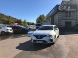 une voiture blanche garée devant un immeuble devant lequel sont garées d'autres voitures
