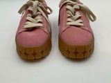 pink sued sneakers with laces on the soles