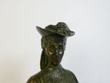 statue en bronze représentant une femme coiffée d'un chapeau