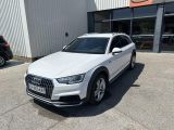 a white audi suv parked in front of a building