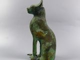 a bronze statue of a cat sitting on its hind legs