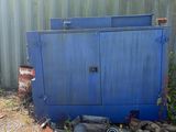 une photo d'une benne bleue à côté d'un immeuble