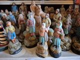 de nombreuses figurines représentant des personnes, posées sur une étagère