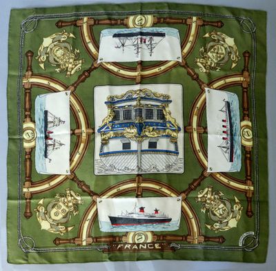 a close up of a green scarf with a picture of a ship