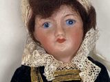 a doll that is wearing a black dress and a cat hat