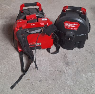two milwaukee tools are sitting on the floor next to each other
