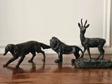 three figurines of a dog and a deer on the floor