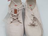 une paire de chaussures blanches à lacets posée sur une surface blanche