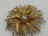 a close up of a gold brooch with diamonds on it
