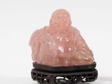 paire de figurines en jade rose représentant un Bouddha assis, posées sur un socle noir