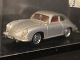 a silver toy car in a clear case on a table