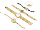 Plusieurs montres et bracelets sont disposés sur une surface blanche