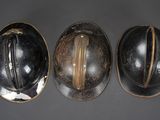 three helmets are lined up on a gray surface