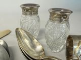 a silver spoon and two silver salt and pepper shakers on a table