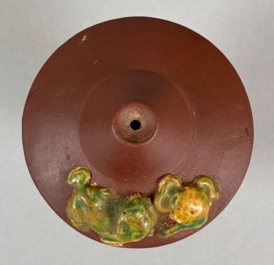 a brown plate with a green and yellow design on it