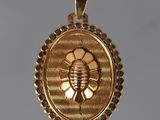 un gros plan d'un pendentif en or orné d'une abeille