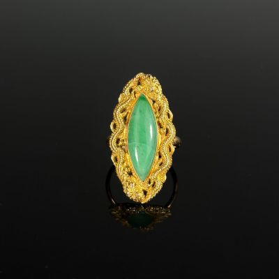 a gold ring with a green jade stone in the center