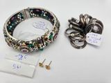 a close up of a bracelet and earring on a white surface