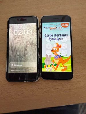 two cell phones sitting on a table next to each other