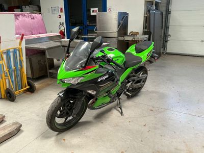 a green motorcycle that is parked in a garage