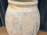 un grand pot en pierre posé sur une table en bois