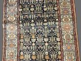 an antique persian rug with a floral design on a black ground