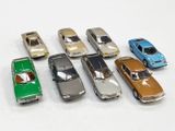 plusieurs petites voitures sont alignées sur une surface blanche