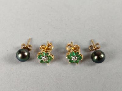 three pairs of black pearls and emerald earrings on a white surface