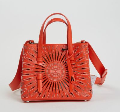 un sac à main orange orné d'un motif représentant des rayons de soleil sur le devant