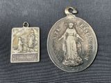 two silver medals of the virgin of guadalupe and the virgin of guadalupe on a black background