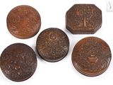 four small wooden boxes with carvings on them sitting on a white surface