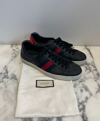a pair of black and red sneakers on a marble surface