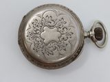 a silver pocket watch on a white surface