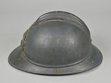 an old helmet is sitting on top of a white table