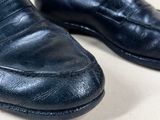 black leather loafers on a white surface