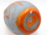 an orange and blue vase on a white surface
