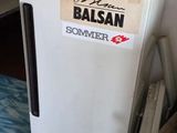 un petit réfrigérateur blanc posé dans un coin de la cuisine