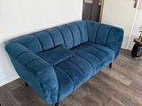 a blue couch that is in a room with wood floors