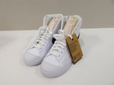 white sneakers with a tag on them sitting on a white table