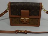 sac à bandoulière Louis Vuitton marron et beige sur un fond blanc
