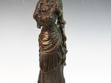 statue en bronze représentant une femme en robe et chapeau, avec un oiseau sur l'épaule