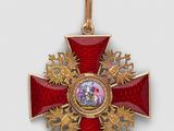 une image représentant une croix rouge et dorée sur laquelle figure le portrait d'un homme
