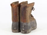 an old pair of brown boots on a white surface with a white background