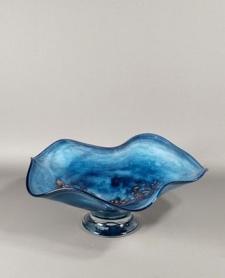 une image représentant un bol en verre bleu posé sur une table
