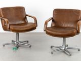 two brown leather swive chairs with casteors and casteors